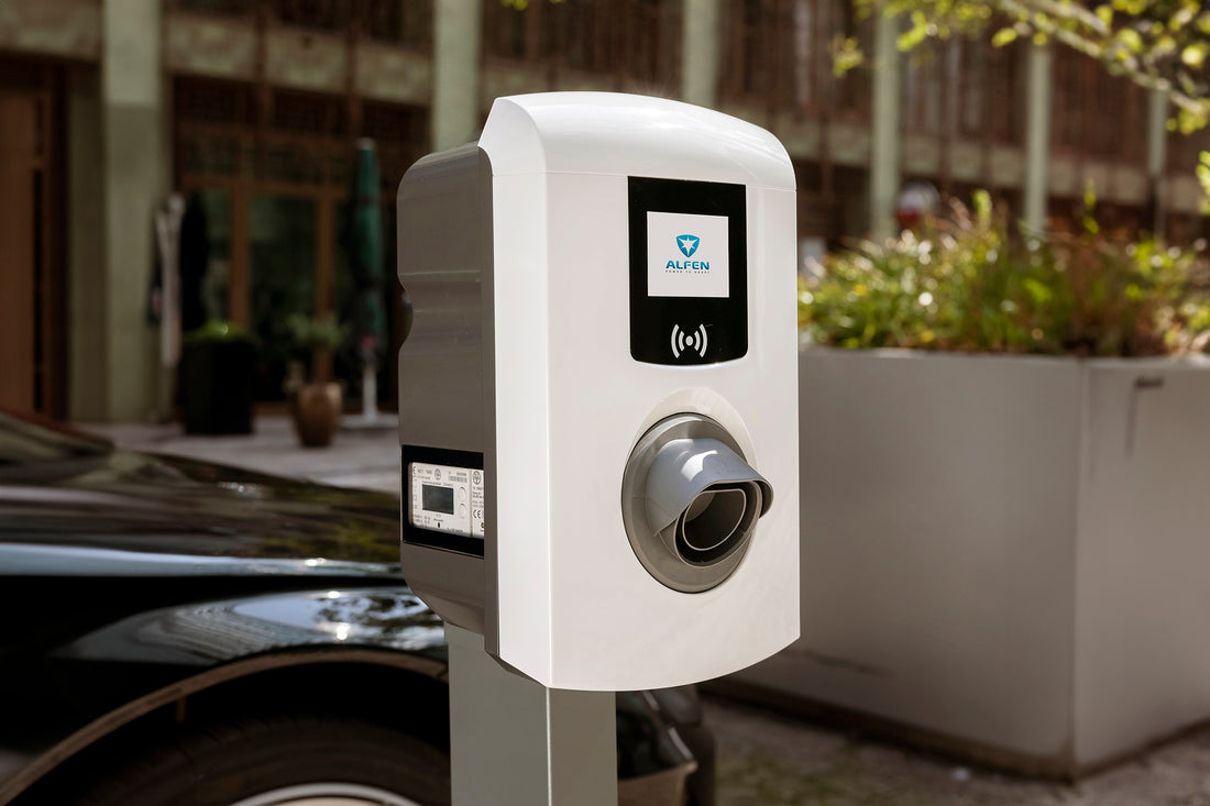 Schließen - von einer Alfen-Einzel-Linieliche Station (Alfen-Einzel-Linie) für Elektrofahrzeuge im Freien, mit einem schwarzen Autopark und einem Gebäude im Hintergrund.