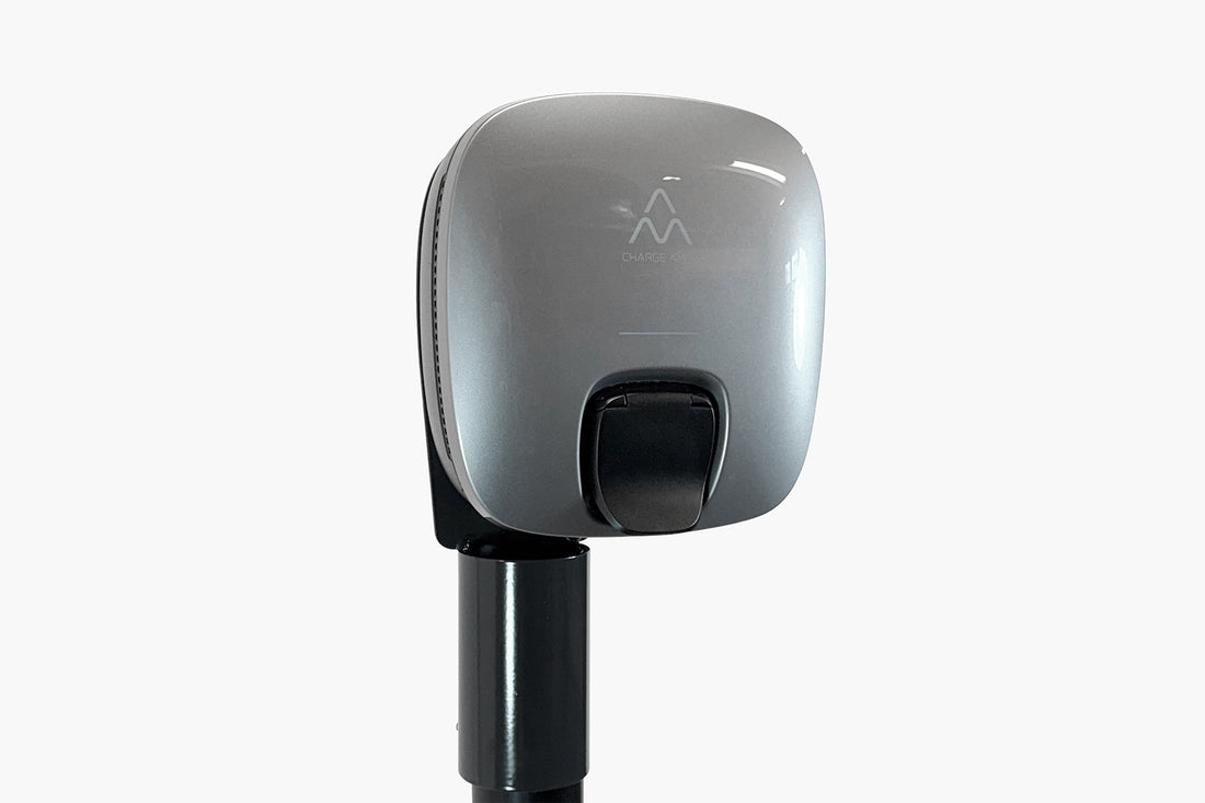 Die Charge Amps Luna von Charge Amps ist eine silberne Ladestation für Elektrofahrzeuge mit schwarzem Sockel, kompaktem Display und zukunftssicherer Technologie auf weißem Hintergrund.