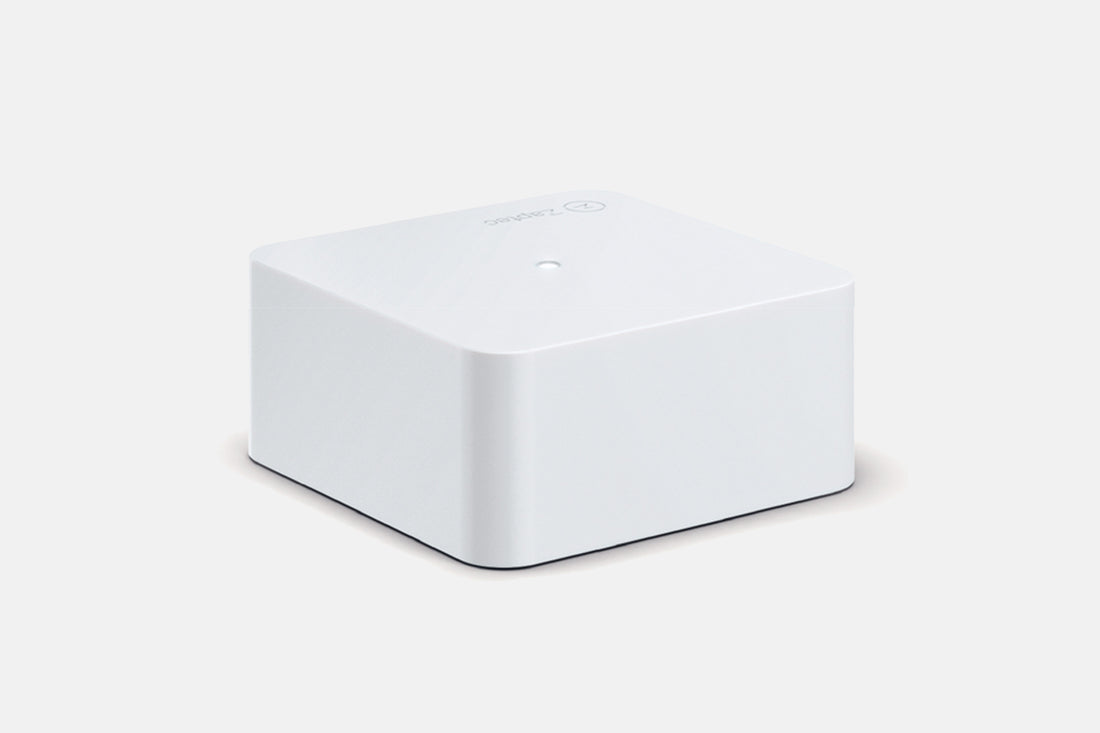 Das Zaptec Sense Gateway Kit von Zaptec ist ein kompaktes weißes, quadratisches Gerät mit abgerundeten Kanten und einer einzelnen Taste oben, perfekt für dynamisches Lastmanagement beim Laden von Elektrofahrzeugen, dargestellt auf einem schlichten hellen Hintergrund.