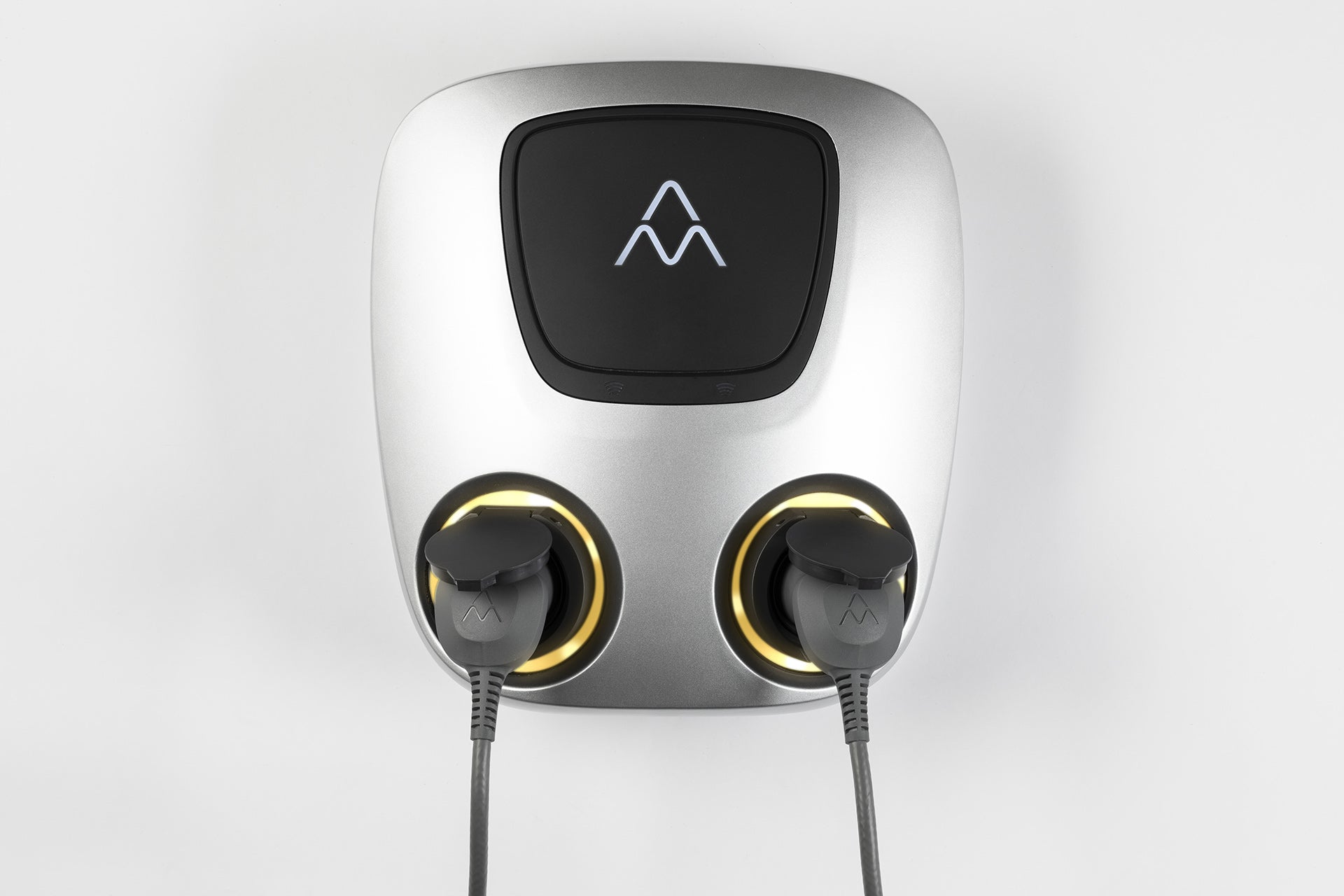 Die Charge Amps Aura von Charge Amps ist eine moderne Ladestation für Elektrofahrzeuge mit zwei verbundenen Ladepunkten, beleuchteten Ringen, RFID-Autorisierung und einer digitalen Anzeige mit einem weißen Logo auf der grau-schwarzen Oberfläche.