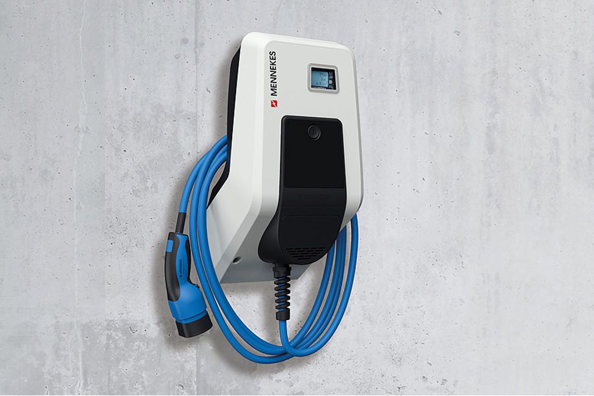 Die Mennekes AMTRON® Professional, eine weiße wandmontierte Elektroauto-Ladestation von Mennekes mit blauem Spiralkabel und integriertem Energiezähler, ist an einer grauen Betonwand befestigt.